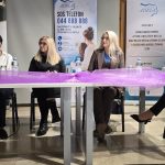 Četiri sudionice tribine za stolom ispred transparenata Centra za žene Adela.
