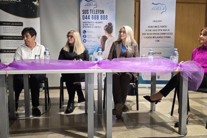 Četiri sudionice tribine za stolom ispred transparenata Centra za žene Adela.