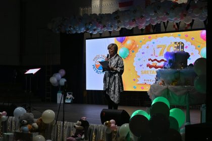 Govornica uz rođendansku dekoraciju i broj 70 na proslavi vrtića Petrinjčica.